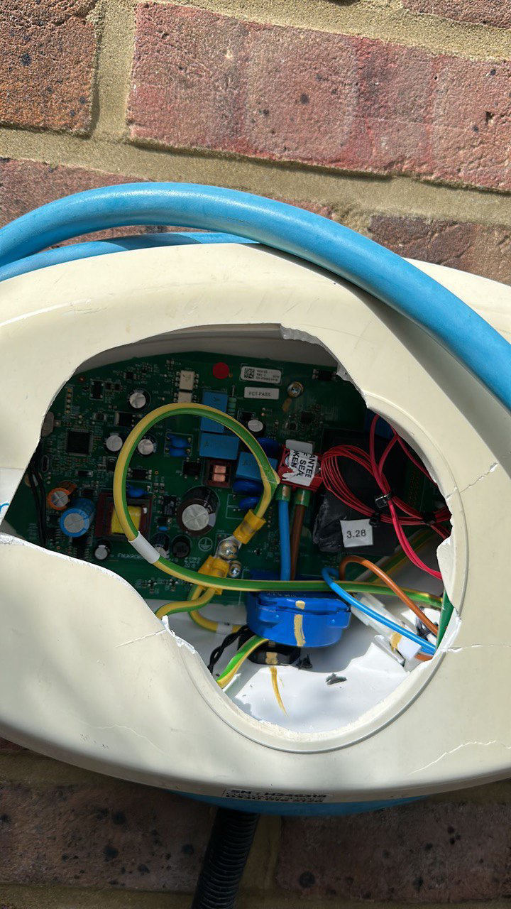 EV charge point with its front panel broken out, exposing the circuit board and wiring inside