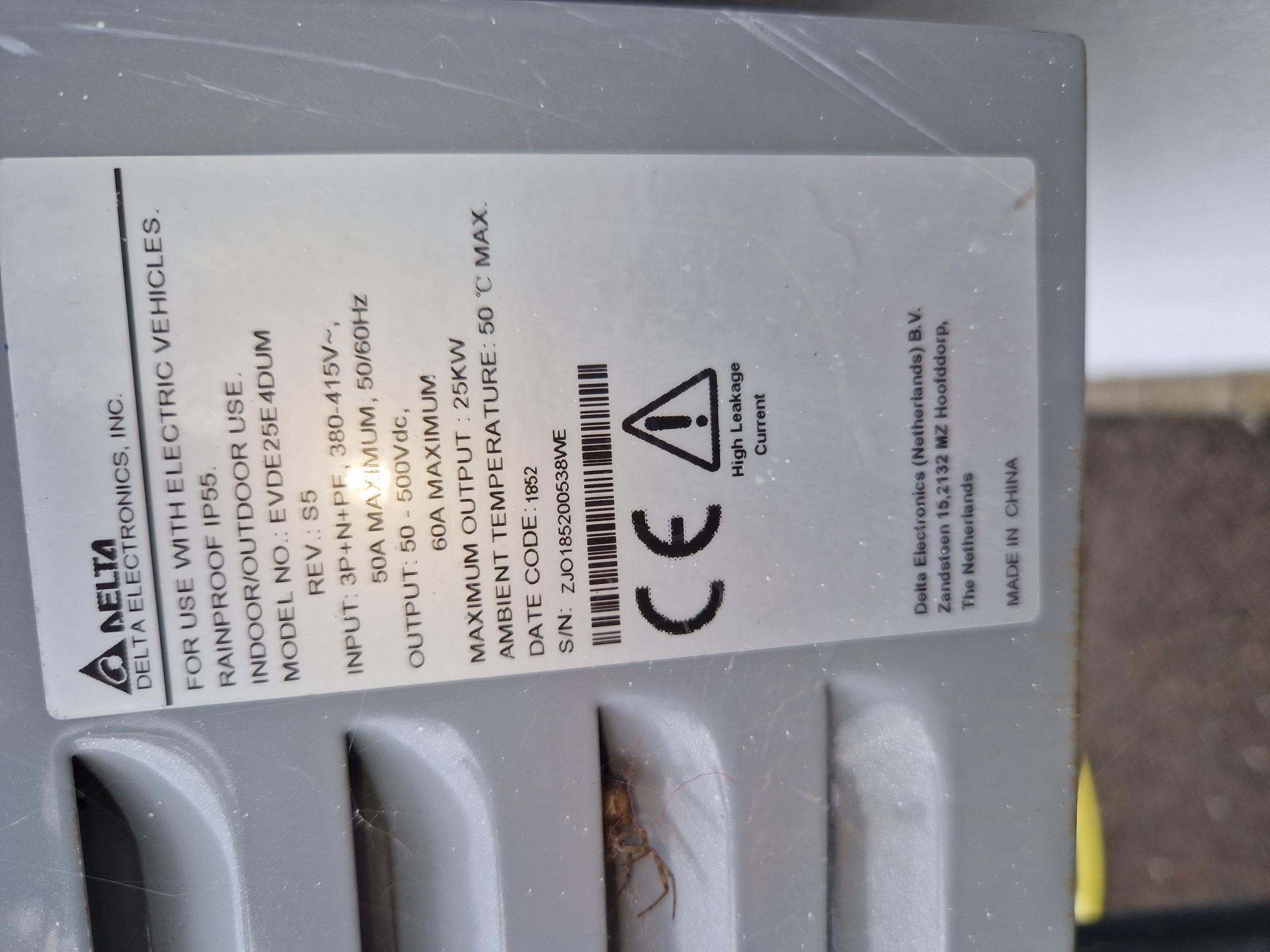 Delta EVDE25E4DUM rating label, with cobwebs and debris visible in the ventilation louvres beside it