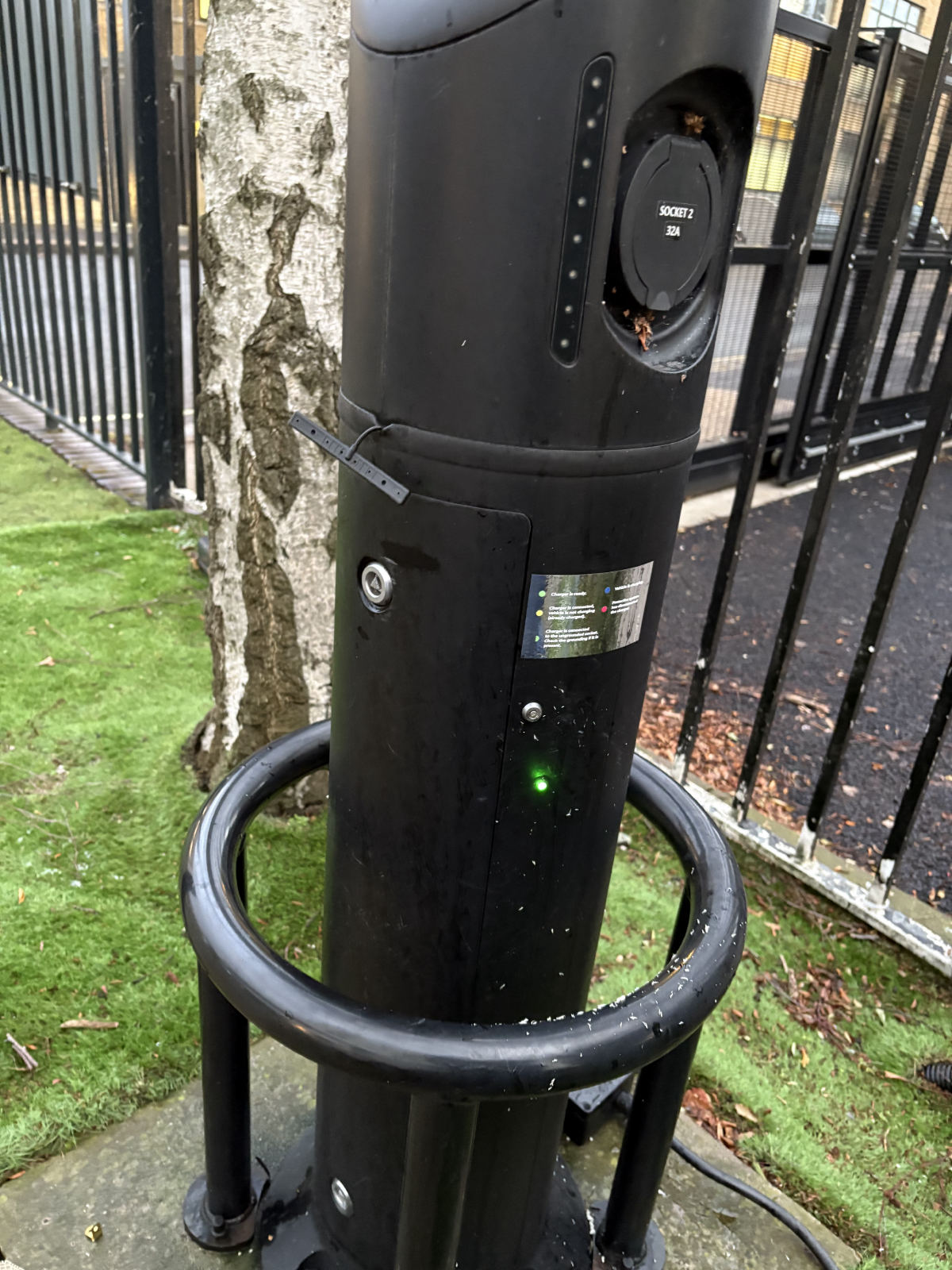 EV charge point with a steady green status light and a printed label listing what each colour means